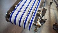 Umlenkung eines Riemenförderer mit Riemen zum Abtransport von Schlauchbeuteln mit blauen, extra haftenden Riemen