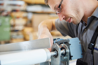 Ein euroflex Mitarbeiter stellt professionell den Gurtlauf eines GB-flex Gurtförderer ein. 